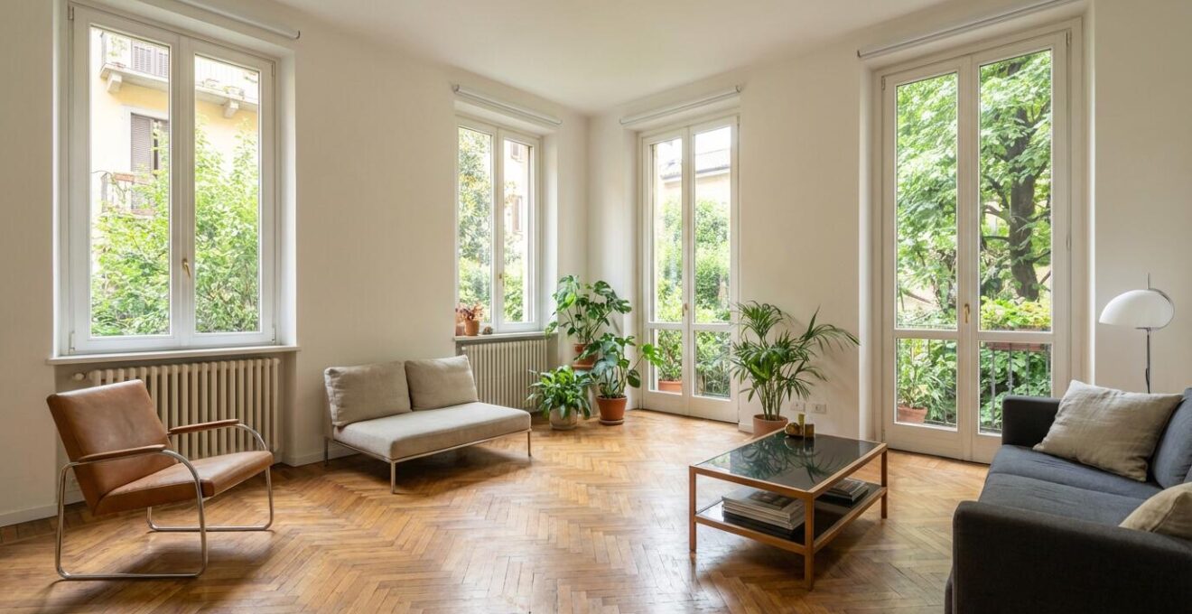 Interno luminoso di appartamento milanese ristrutturato con parquet e ampie finestre